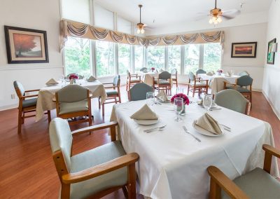 Dining area with linen tablecloths and place settings at Monterey Care Center